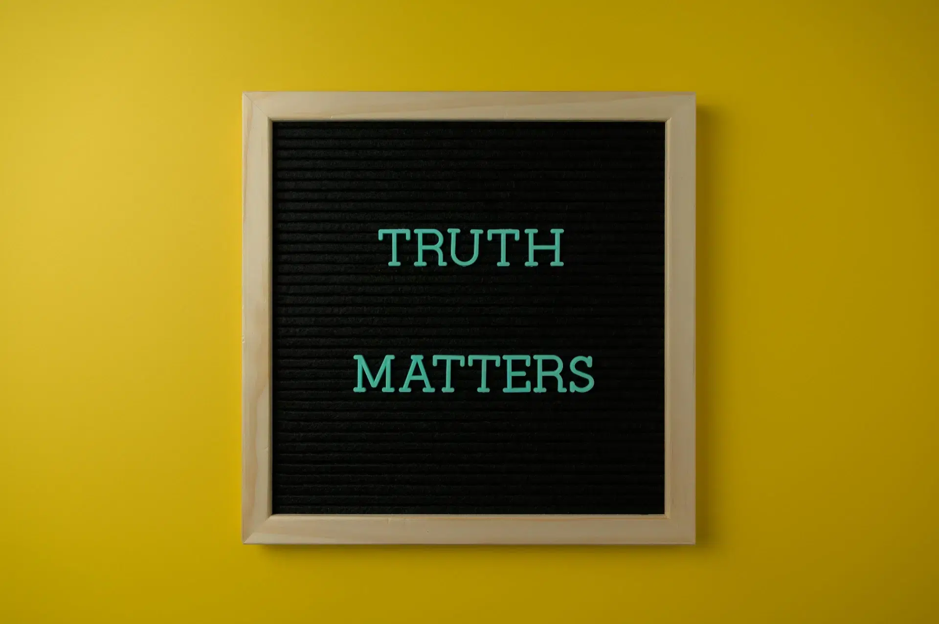 A letterboard displaying the words “TRUTH MATTERS” on a yellow background