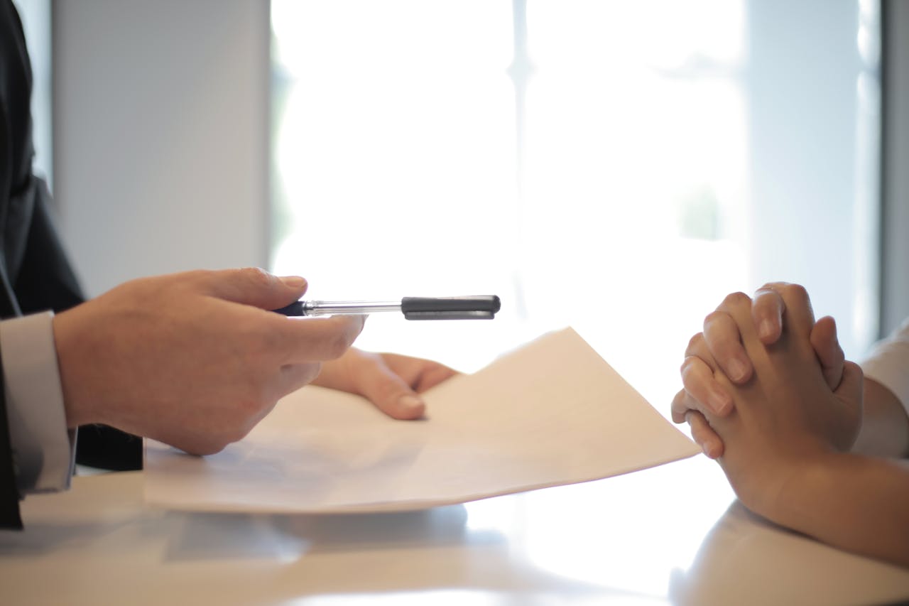 pre-trial-negotiation pre-trial negotiation in progress, indicated by an attorney handing over a pen