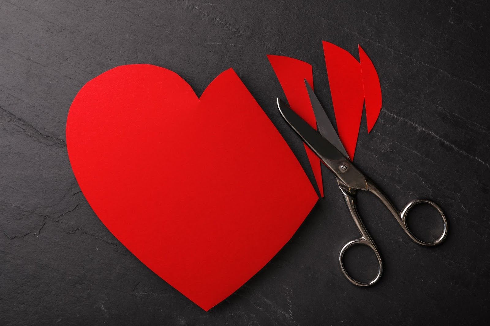 A paper heart with multiple cuts from a pair of scissors