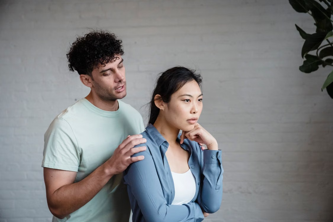 A man talking to his girlfriend who has her back to him